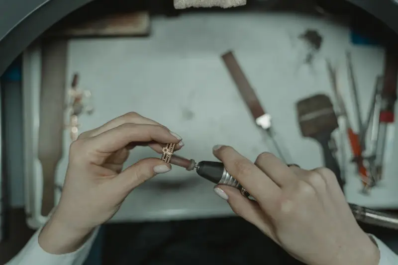 Jeweler polishing a ring with a rotary tool in a workshop