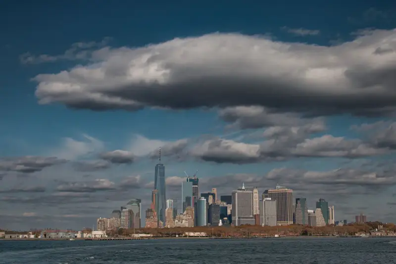 New York City skyline of Manhattan towers under dramatic clouds in daylight