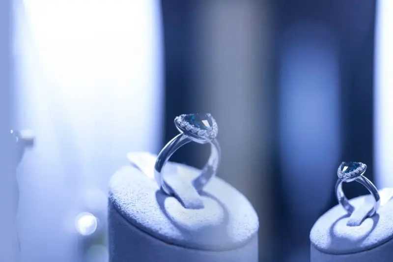 Close-up of silver rings set with blue gemstones on a display
