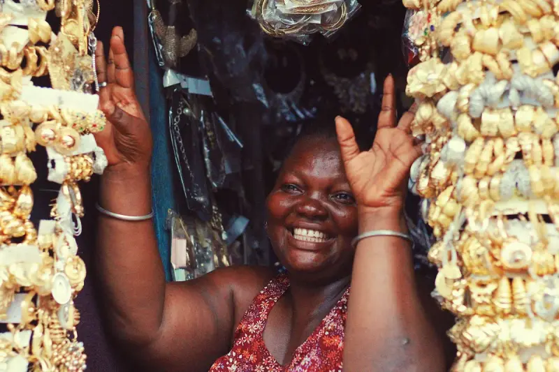 Smiling woman surrounded by displays of gold jewelry