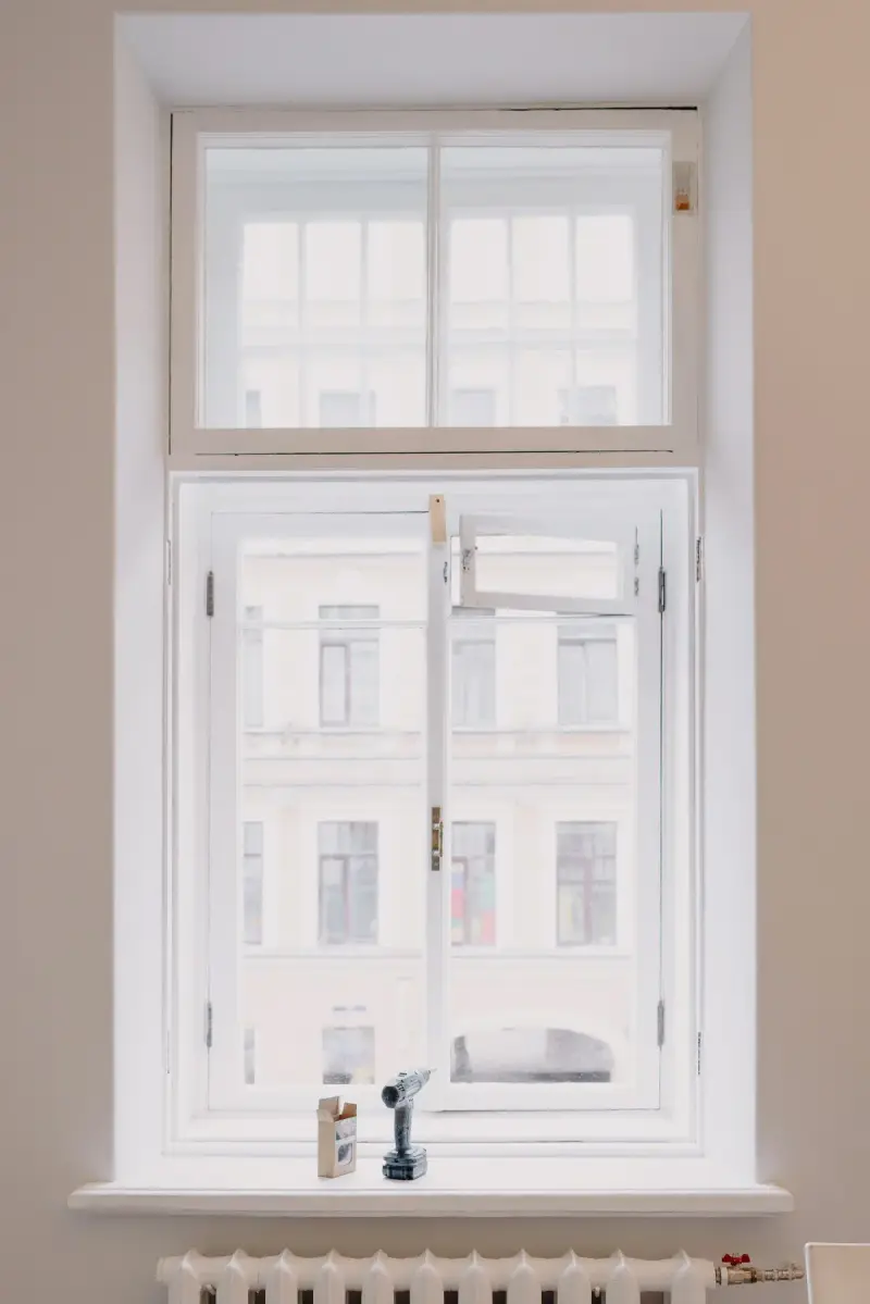 Newly installed wooden window with a drill resting on the sill