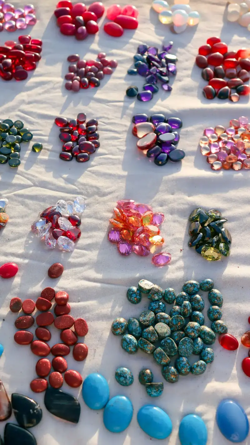Rows of red jasper, amethyst, turquoise and green stones laid out on a cloth