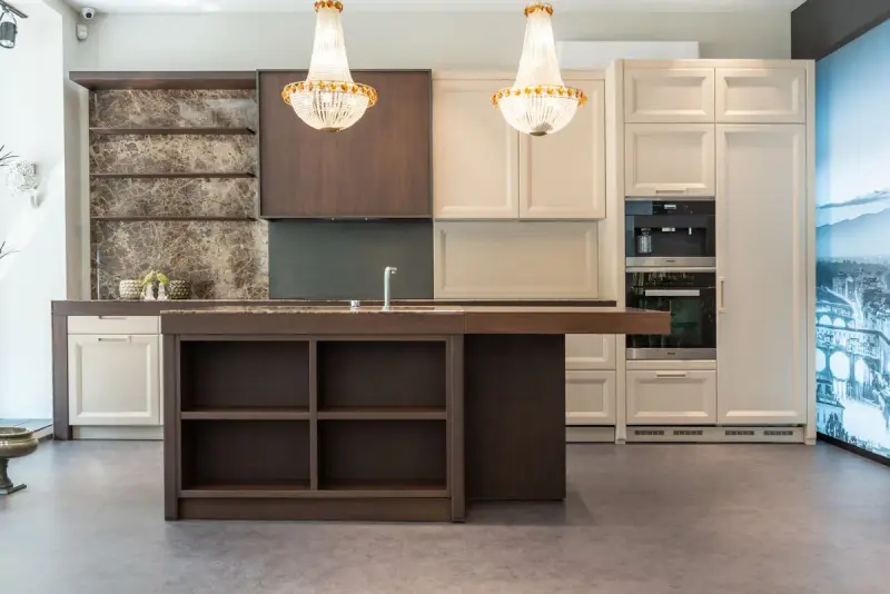 Kitchen with a dark wood island, cream cabinets and crystal chandeliers