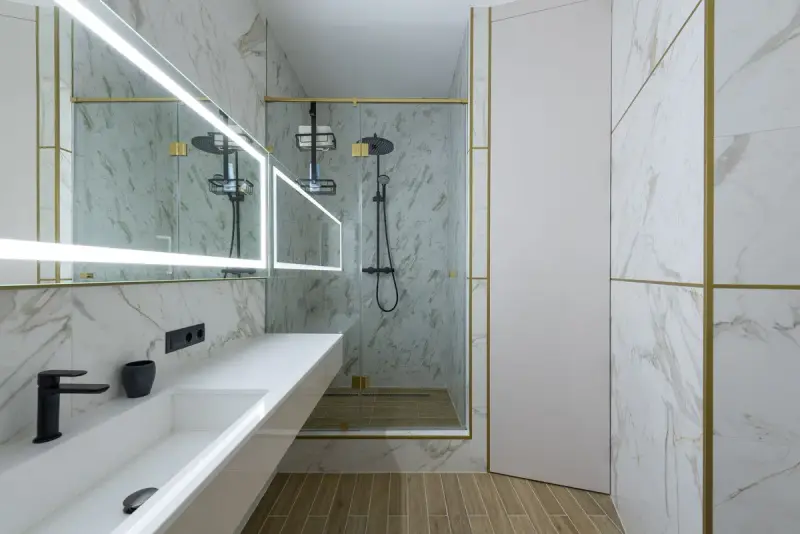 Bathroom with marble-look wall tiles, a long sink, LED mirror and walk-in shower