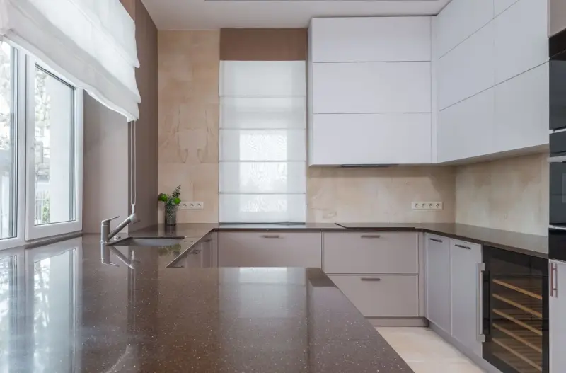 Kitchen corner with a stone countertop, undermount sink and chrome faucet by a window