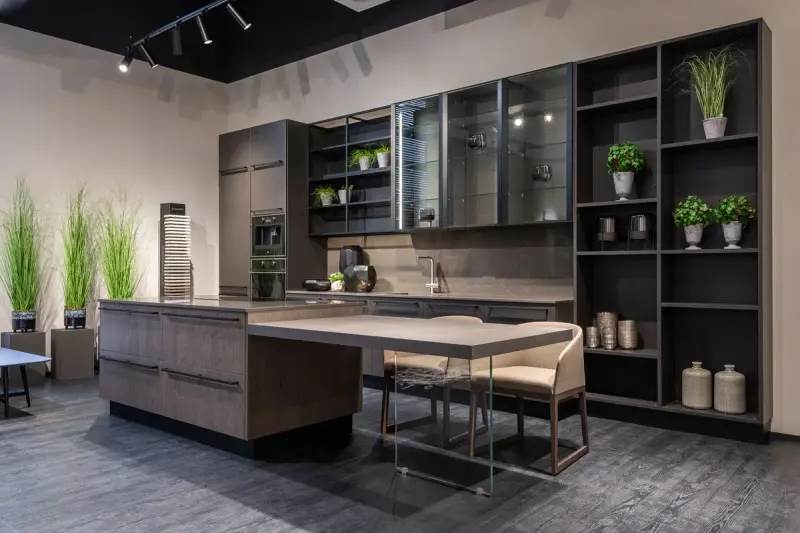 Kitchen with a wood island, open shelving and potted plants in a showroom