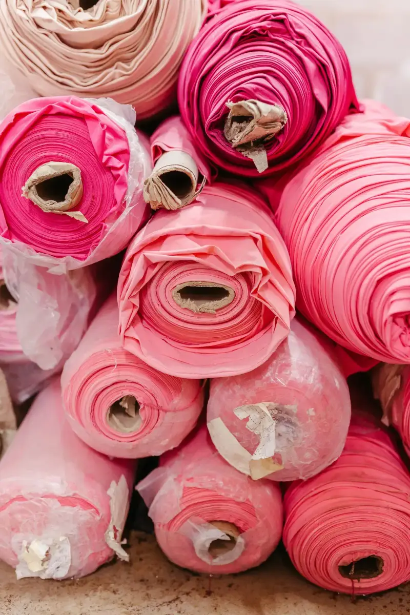 Stacked rolls of pink and fuchsia fabric