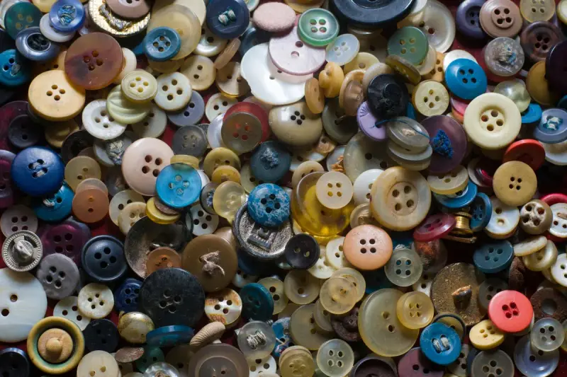 A scatter of colorful clothing buttons in many sizes