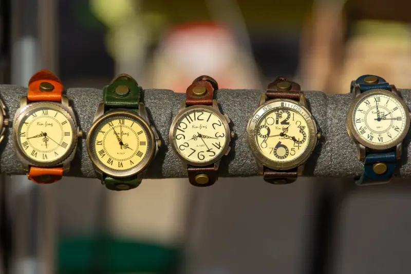 Assorted vintage wristwatches with leather straps on a display rack
