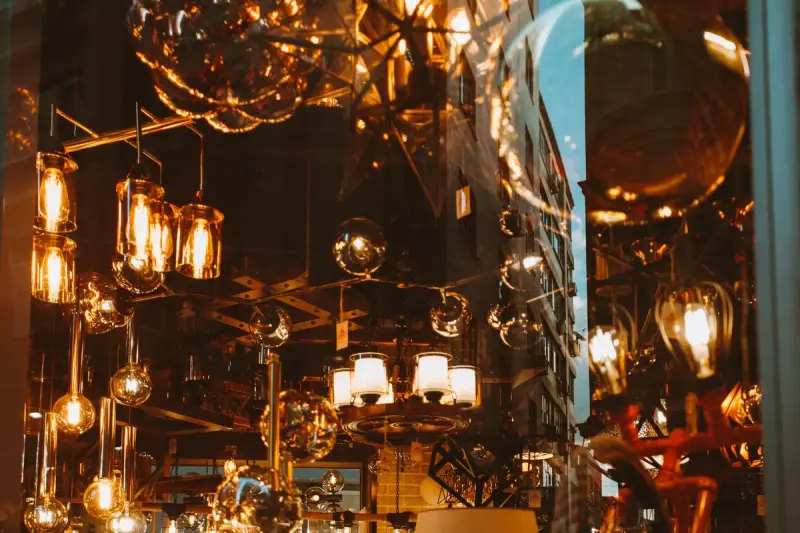 Glowing glass pendant lamps and Edison bulbs hanging from a lighting store ceiling