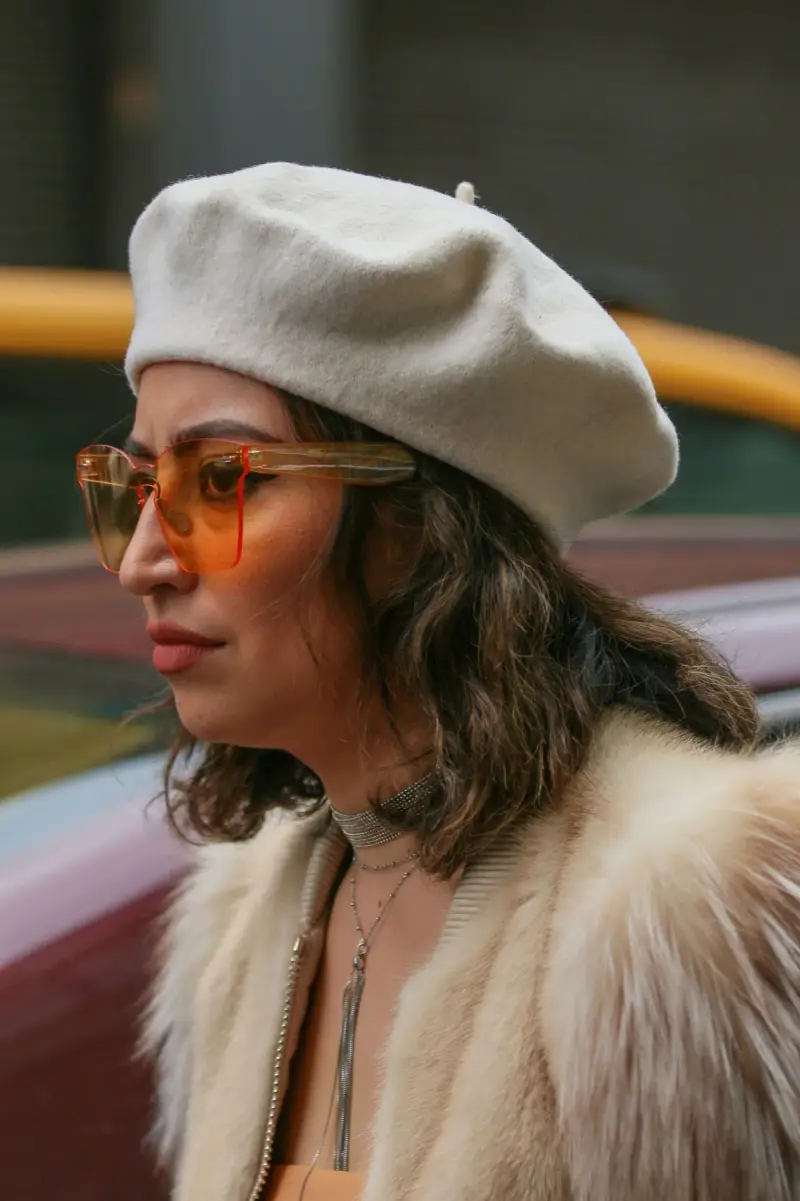 Woman in a beret and frameless orange-tinted sunglasses, New York street style