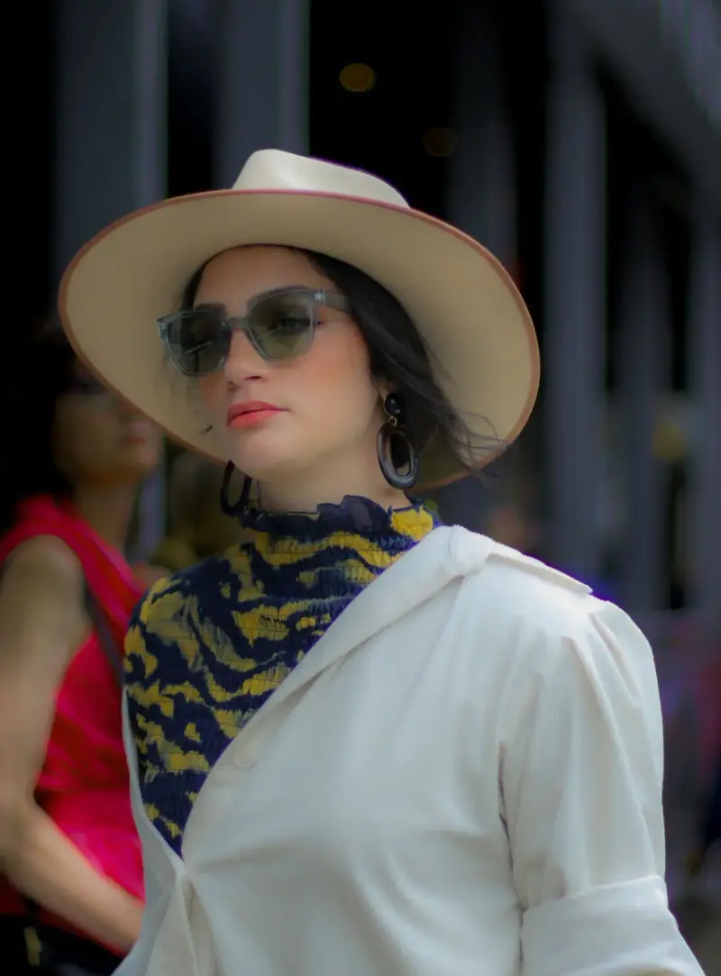 Woman in translucent gray sunglasses and a wide-brim hat, New York street style