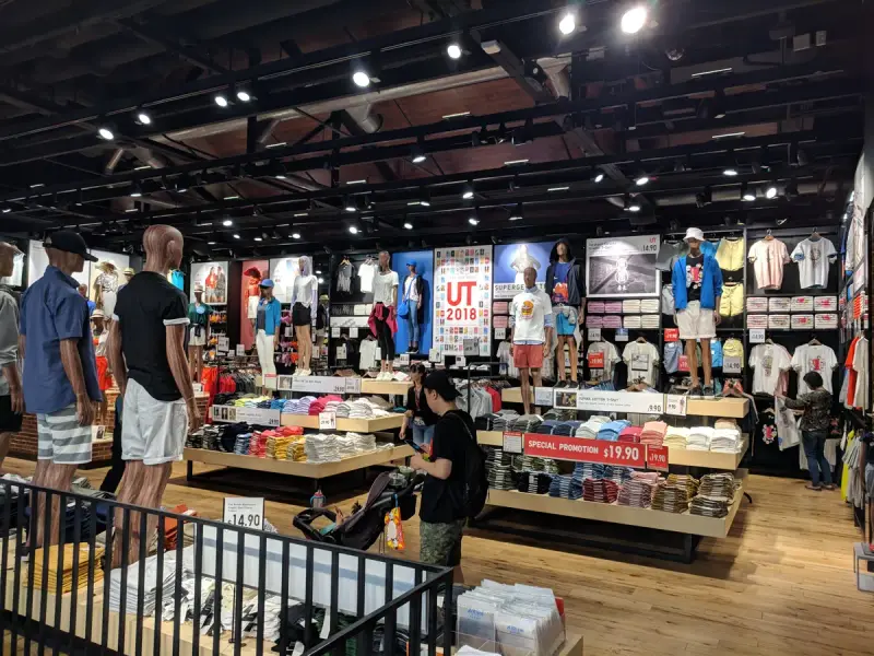 Clothing store aisle with rails of shirts, jackets and folded stock