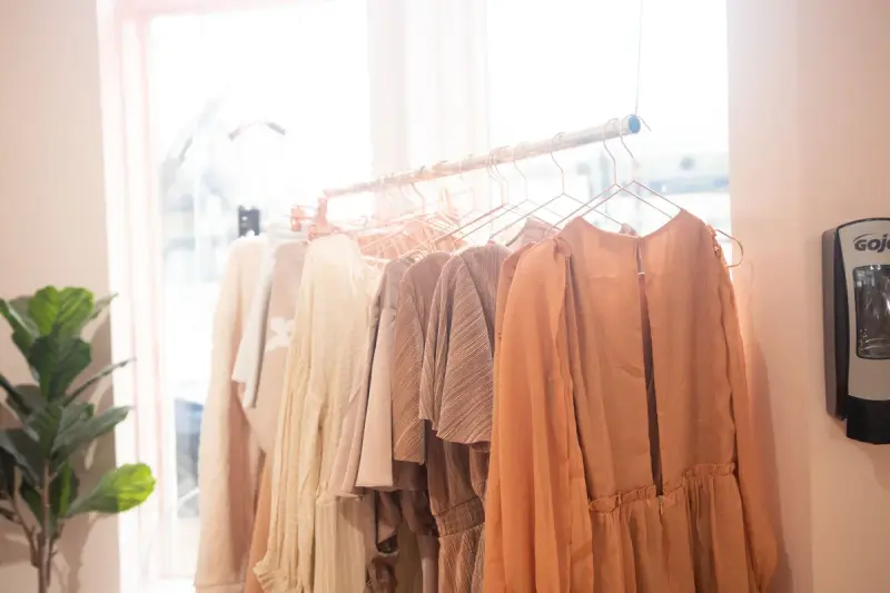A row of women's dresses on hangers in a bright boutique