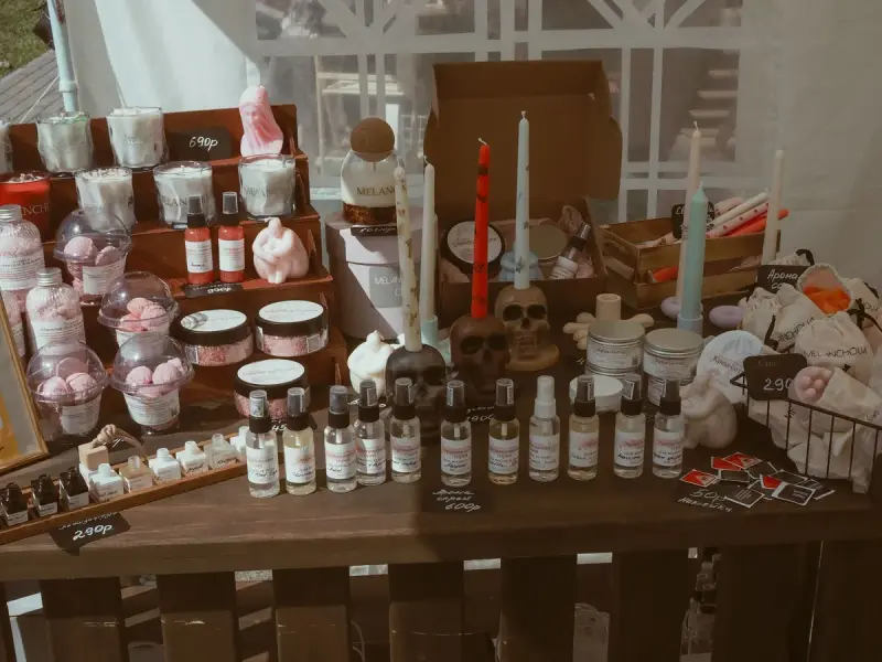Handmade candles, skincare items and decor arranged on a market table