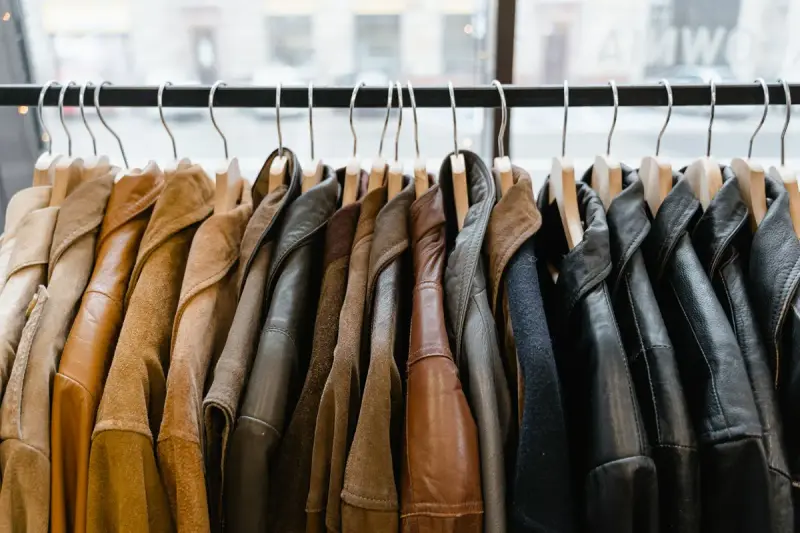 Row of leather and suede jackets on hangers in tan, brown and black