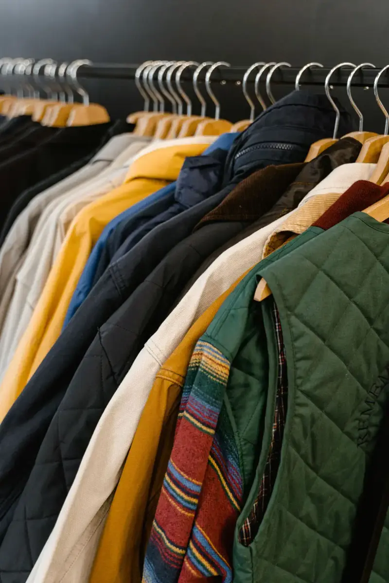 Colorful jackets, a quilted vest and outerwear packed on a rack