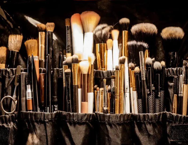 Dozens of professional makeup brushes standing upright in a black brush belt