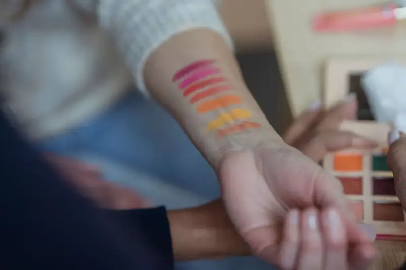 Eyeshadow swatches in pink, orange and yellow tested on a forearm