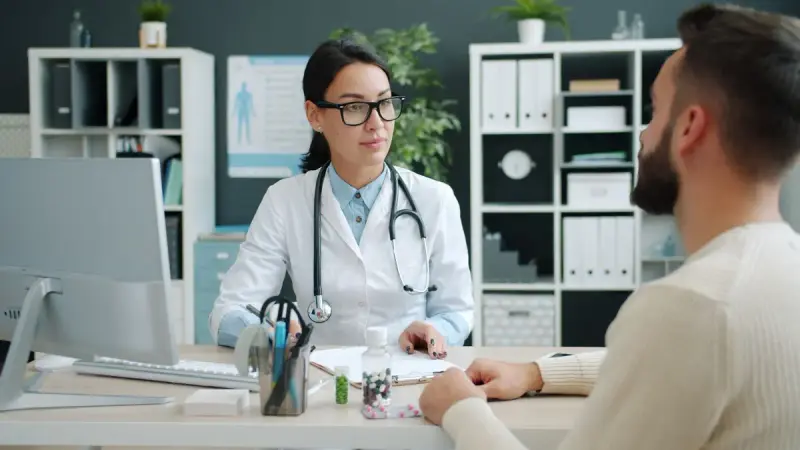Doctor consulting with a visitor in a modern clinic office