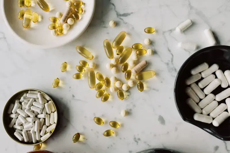 Top view of assorted pills and capsules sorted on a marble countertop