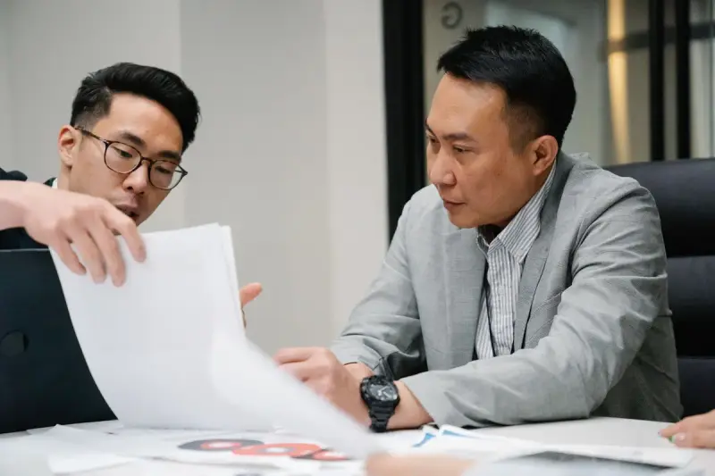 Two professional men discussing a document in a contemporary office