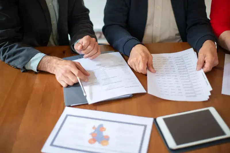 Two professionals reviewing documents during a meeting