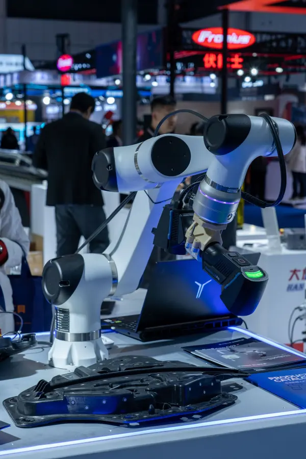 Robotic arms and demonstration fixtures displayed at a technology exhibition.