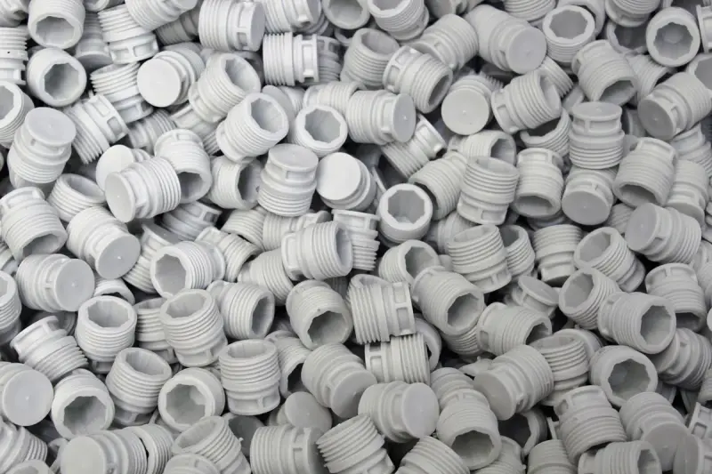 Heap of white molded plastic screw caps fresh from production
