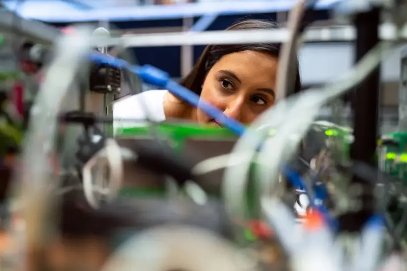 Engineer looking through cables and circuit boards of a prototype test setup