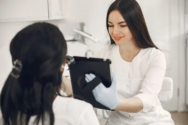 A beautician and client discussing information on a tablet