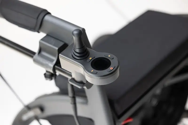 Close view of the joystick controller mounted on the armrest of an electric wheelchair