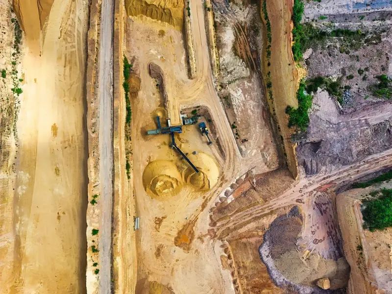 Aerial view of a sand and gravel pit with conveyors, stockpiles and haul roads