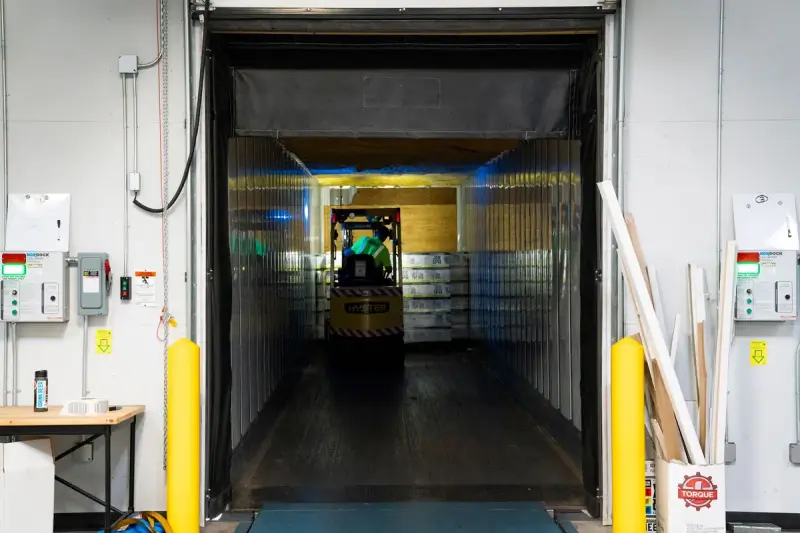 Forklift unloading goods at an indoor warehouse loading dock