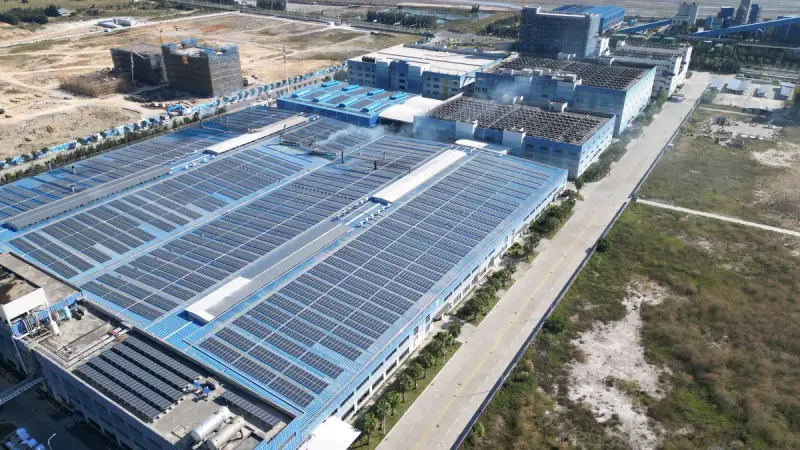 Aerial view of large solar arrays covering an industrial building complex