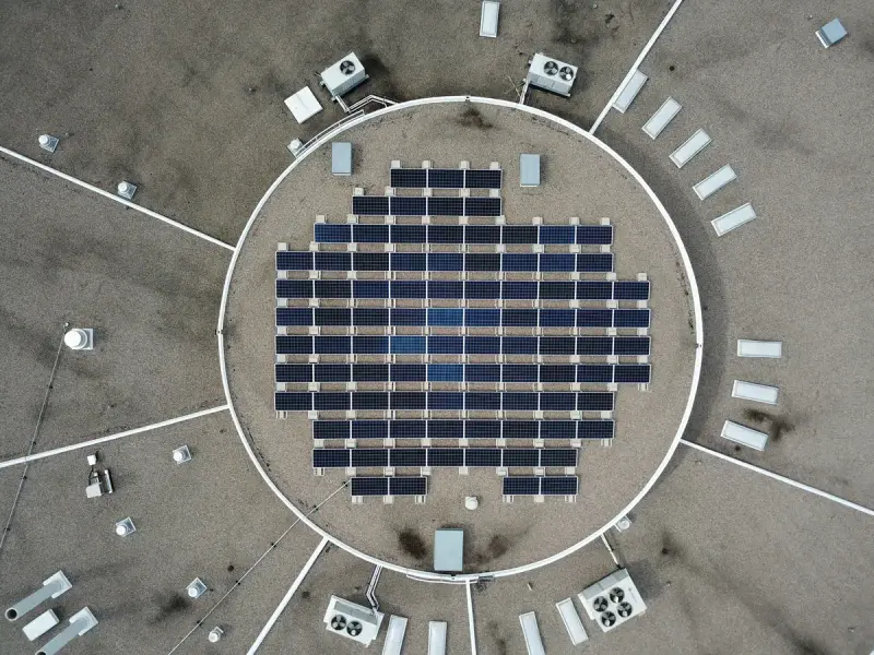 Aerial photo of a dense grid of solar panels on a flat rooftop