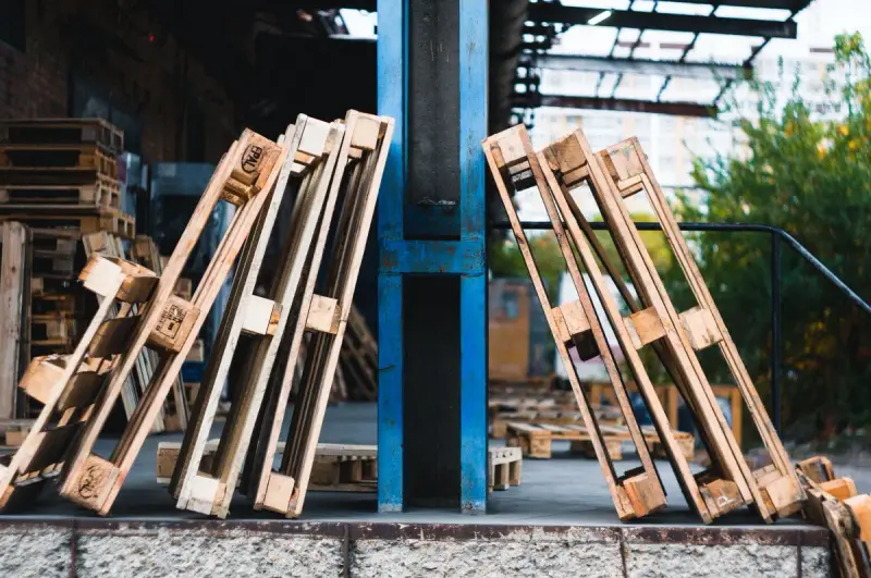 Wooden pallets stacked in an outdoor warehouse yard