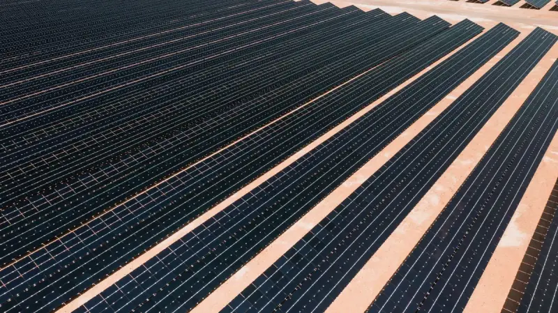 Aerial close view of long rows of solar panels in a utility-scale farm