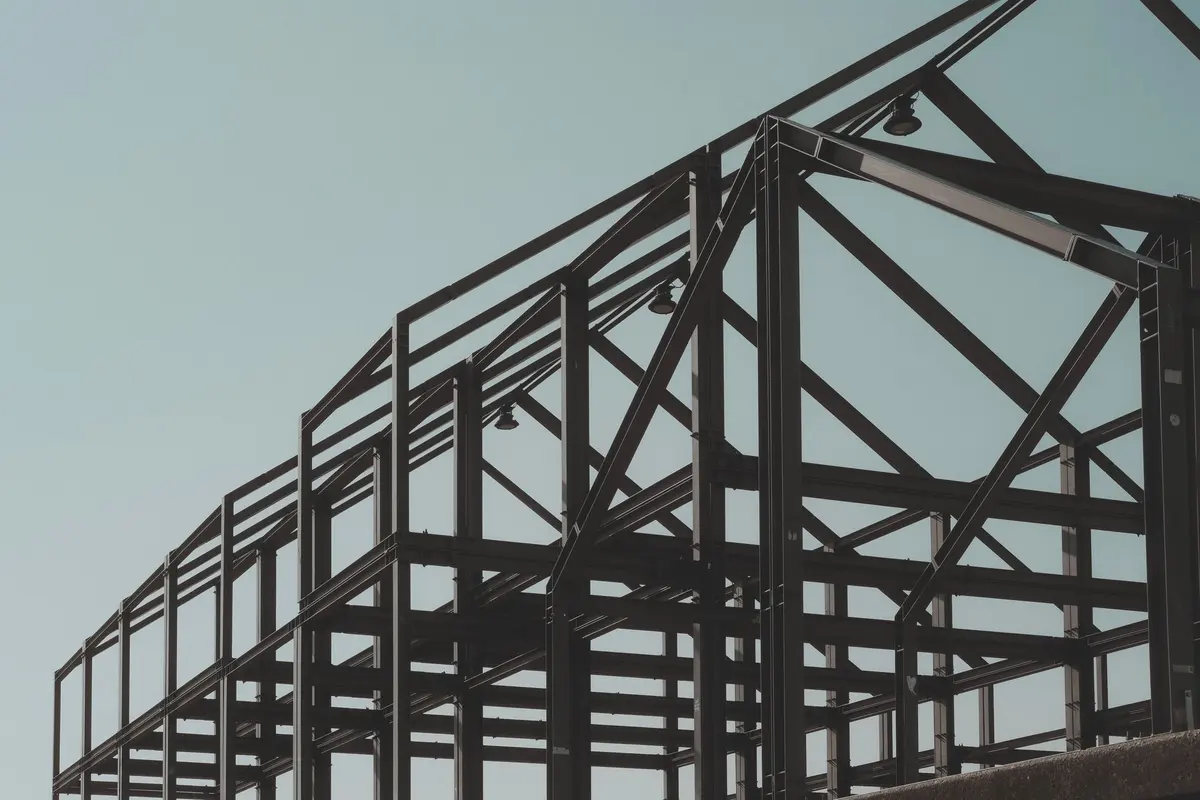 Structural steel building frame of columns and beams against a clear blue sky