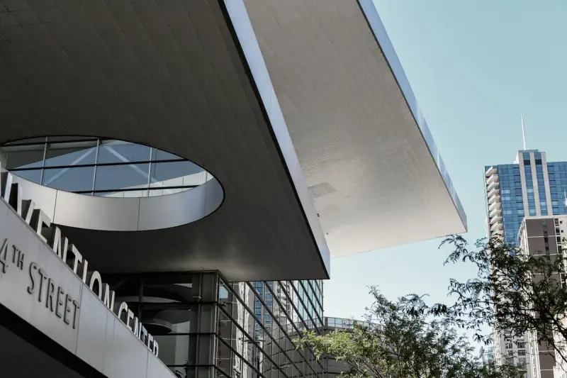 Glass facade of the Colorado Convention Center with the downtown Denver skyline