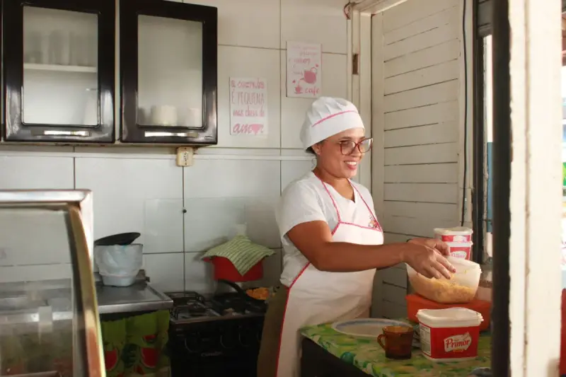 Woman in an apron preparing food at a kitchen work surface