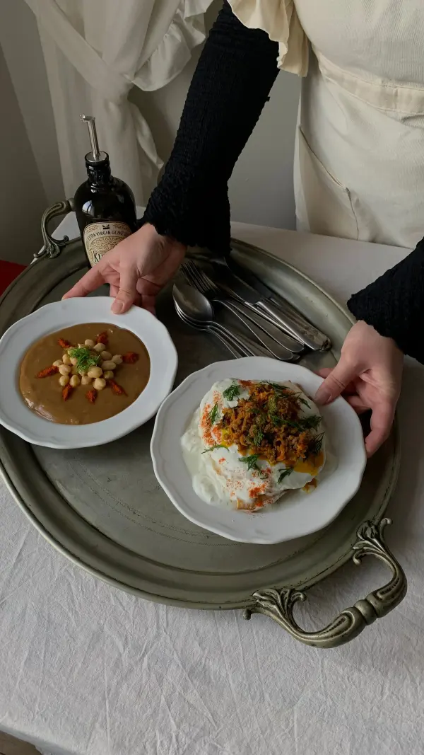 Cook arranging individual dishes on a serving tray
