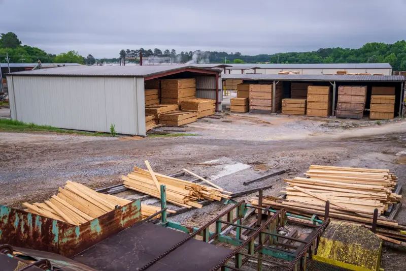 Neatly stacked wooden planks inside a covered lumber storage building