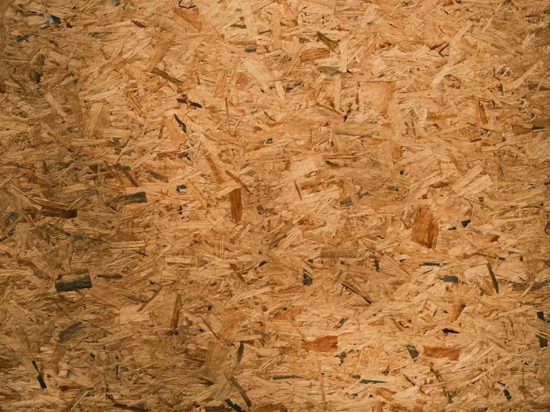 Close-up texture of an oriented strand board panel in brown tones