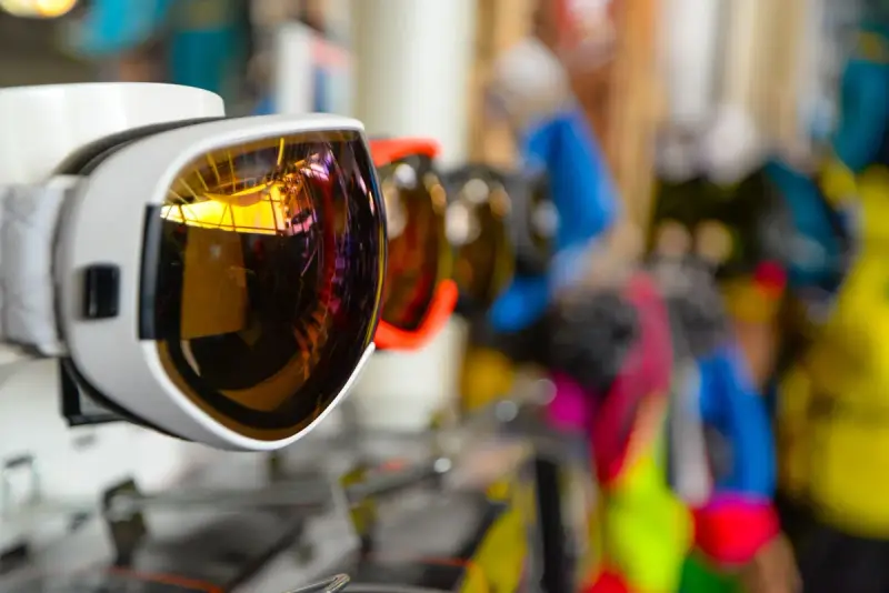 Row of mirrored ski goggles on a store display in bright colors