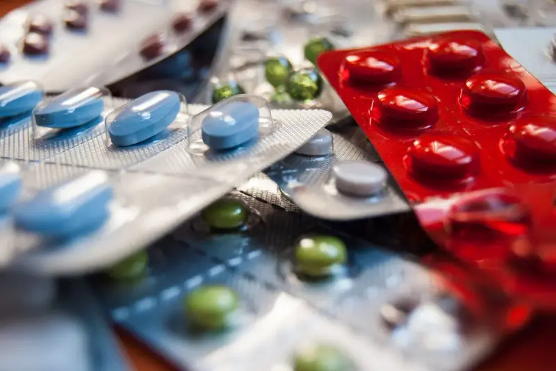 Close-up of blue, red and green tablets in foil blister packs