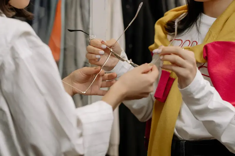 Two women handling and comparing eyewear in a boutique