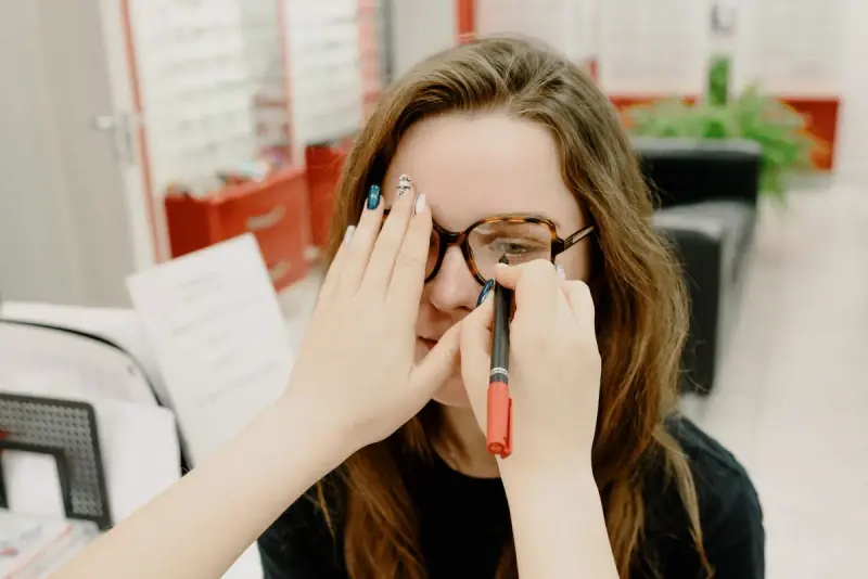 Young woman covering one eye during a quick vision check in an optical shop