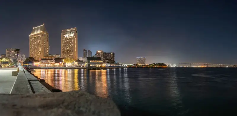 San Diego bay at night with lit towers and the Coronado bridge