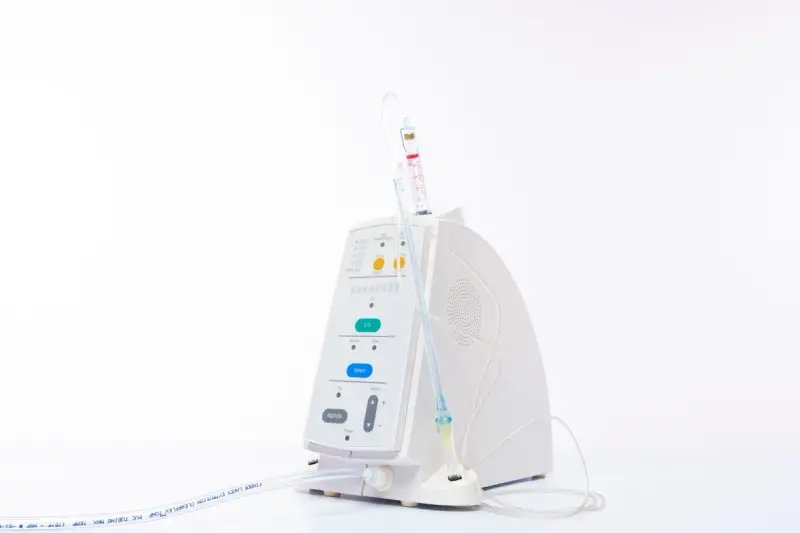 Compact white infusion device with tubing on a plain white background